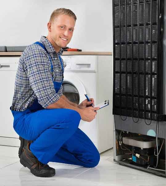 Fridge Repairs: Technician repairing the back of a refrigerator.
